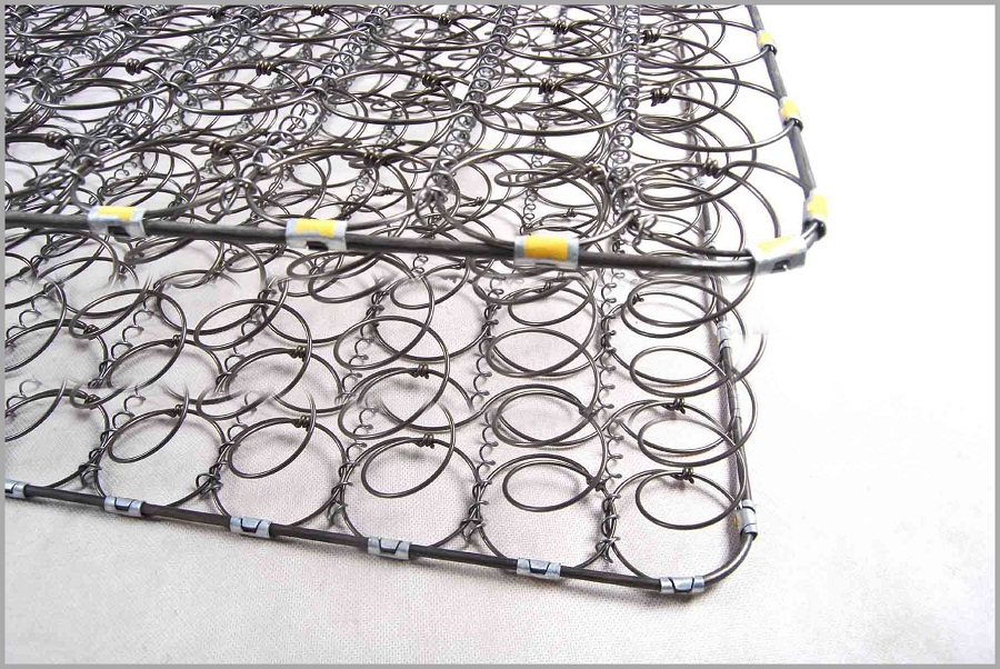 Nệm lò xo liên kết gồm nhiều con lò xo được đan lại với nhau bằng cách mối kim loại, tạo thành một khung kim loại vững chắc
