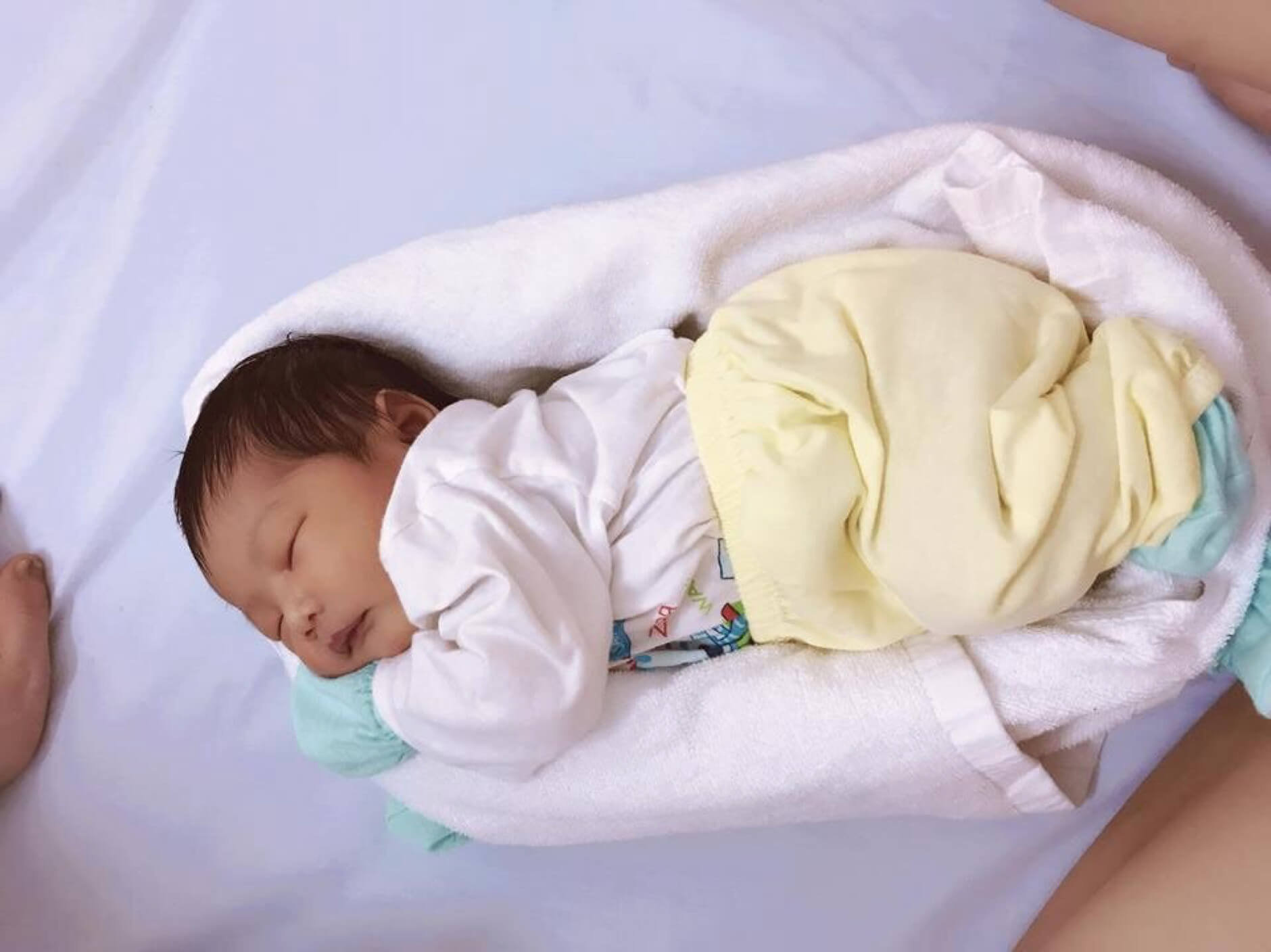 Quấn khăn tạo ổ giúp bé ngủ ngon hơn trong tư thế nằm nghiêng
